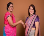two mature indian women shaking hand greeting agreement studio shot wearing sari traditional clothes together against 129610408.jpg from indian shaking