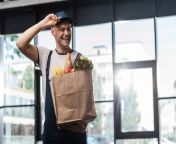happy delivery man touching cap holding paper bag happy delivery man touching cap holding paper bag groceries 190397404.jpg from delivery man is touching the bum and breast of hot woman