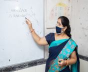female teacher wearing mask saree teach math whiteboard classroom indian school education class covid pandemic 196117582.jpg from indian school madam