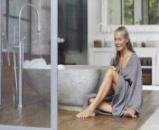 smiling mature woman sitting by bathtub on floorboard in bathroom mcf01505.jpg from mature bathtub