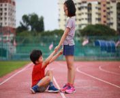 girl giving helping hand to friend fallen on running track eyf08403.jpg from friend giving helping