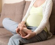 c leg cramps during pregnancy closeup hands massaging swollen foot while sitting sofa 1674527862.jpg from kaki pregnant