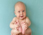 smiling naked baby turquoise background toddler lies back holds his legs with his hands 100739 30.jpg from nude toddler jpg