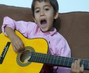 kid singing playing classical guitar.jpg from playing guiter and singing