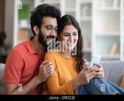 happy young indian couple watching videos on smartphone at home together 2r0dcjr.jpg from desi couple new videos