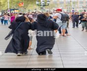 two muslim women wearing black colored burkas walk together along he18jp.jpg from gaand walking