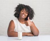 young african american woman sitting on the table drinking a glass of milk happy with big jpgs612x612w0k20cqavfbjd27x1jbxgbwhcxtlwsuchj8l8n66im8hfvw24 from amrica black woman big milk xxx video down