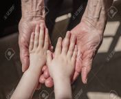 148779968 an elderly woman old lady grandmother holds her little granddaughter s small hands family unity love.jpg from small and young and aged