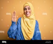 young beautiful brunette muslim woman wearing arab hijab over isolated yellow background waiving saying hello happy and smiling friendly welcome gest 2b55jh4.jpg from arab hiab