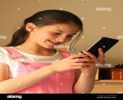young girl pre teen with brown hair smiling as she uses cell smart mobile phone 2e99yhx.jpg from she is cell
