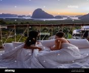 couple man and woman mid age on vacation in thailand waking up in the jungle with bedroom outside watching sunrise over the ocean and jungle of phnanga thailand men and woman in bed outside balcony 2ex9cer.jpg from couple nanga
