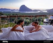 couple man and woman mid age on vacation in thailand waking up in the jungle with bedroom outside watching sunrise over the ocean and jungle of phnanga thailand men and woman in bed outside balcony 2ex9bw1.jpg from couple nanga