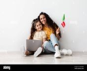 portrait of arab mother and little daughter with laptop and italian flag 2hhnrmf.jpg from mom arb