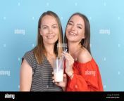 cute girl is having fun with her stylish mom in red dress drinking cocktail at birthday party young mother and happy daughter play together and enjoy delicious milkshake on blue background 2jcf5ce.jpg from plays with her delicious