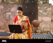 happy indian village woman in saree using the laptop sitting outside the house making an online payment by credit card 2ram0ja.jpg from village tamil house wife bending down blouse nude