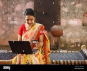 happy indian village woman in saree using the laptop sitting outside the house making an online payment by credit card 2rakyxn.jpg from telugu villege anty