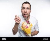 amazed guy is holding a small pack of good popcorn and eting it he has opened his mouth he is not eating popcorn very accurate isolated on white t17ewx.jpg from eting