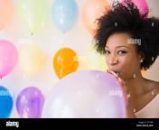 african american woman blowing up balloon for party e7f79b.jpg from woman blows