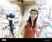 woman recording video by viedo stabilizer at street of bangkok ktaxfj.jpg from viedoxxxx com