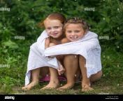 dos naughty little girls sentado en la playa en una toalla despues de banarse en el lago gj78fg.jpg from to 10 nud